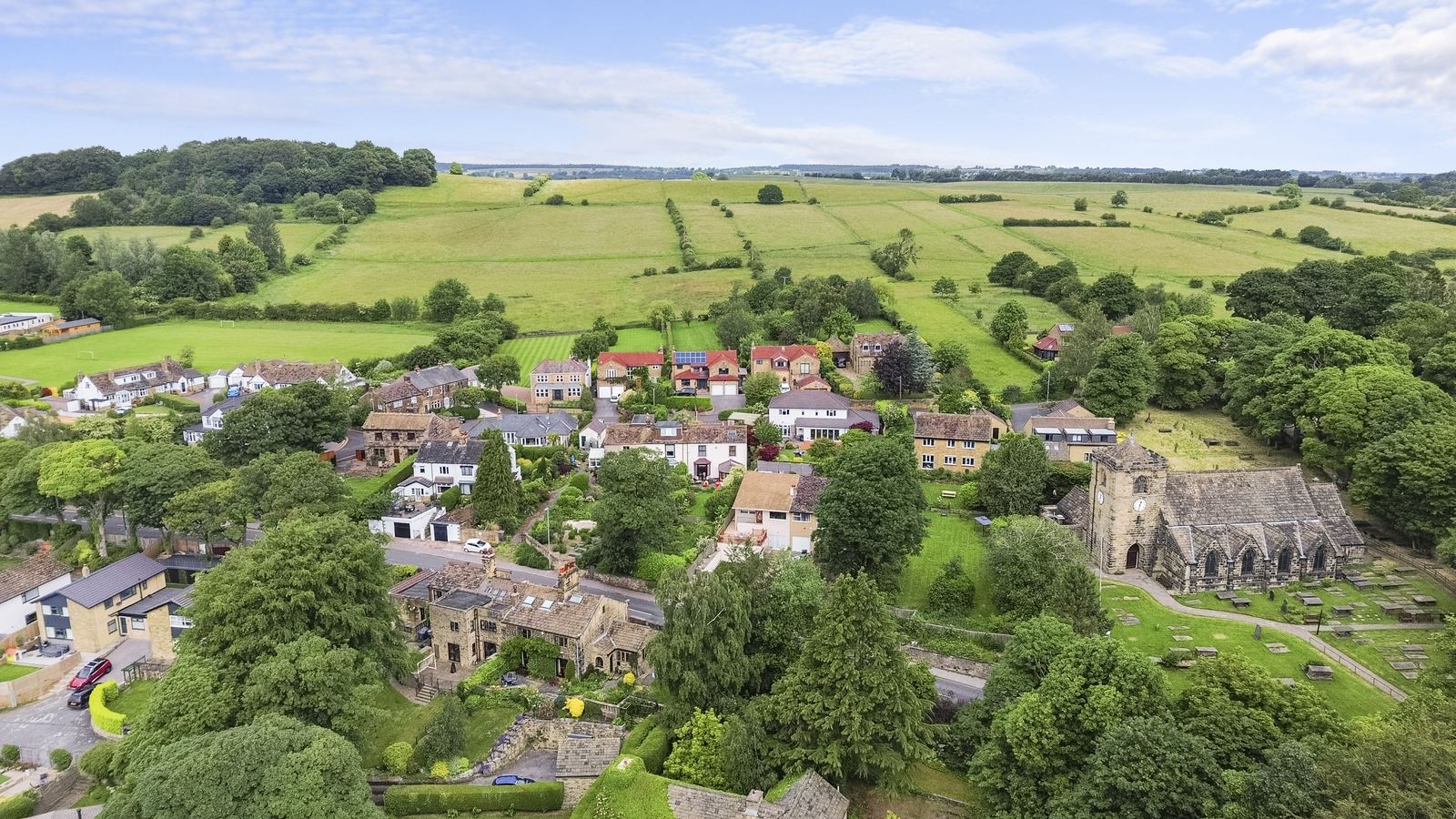 Drone photography over a stone-built village and church near Bradford, West Yorkshire